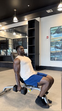 a man is working out on a bench in a gym