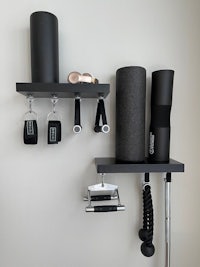 a black wall shelf with various gym equipment on it